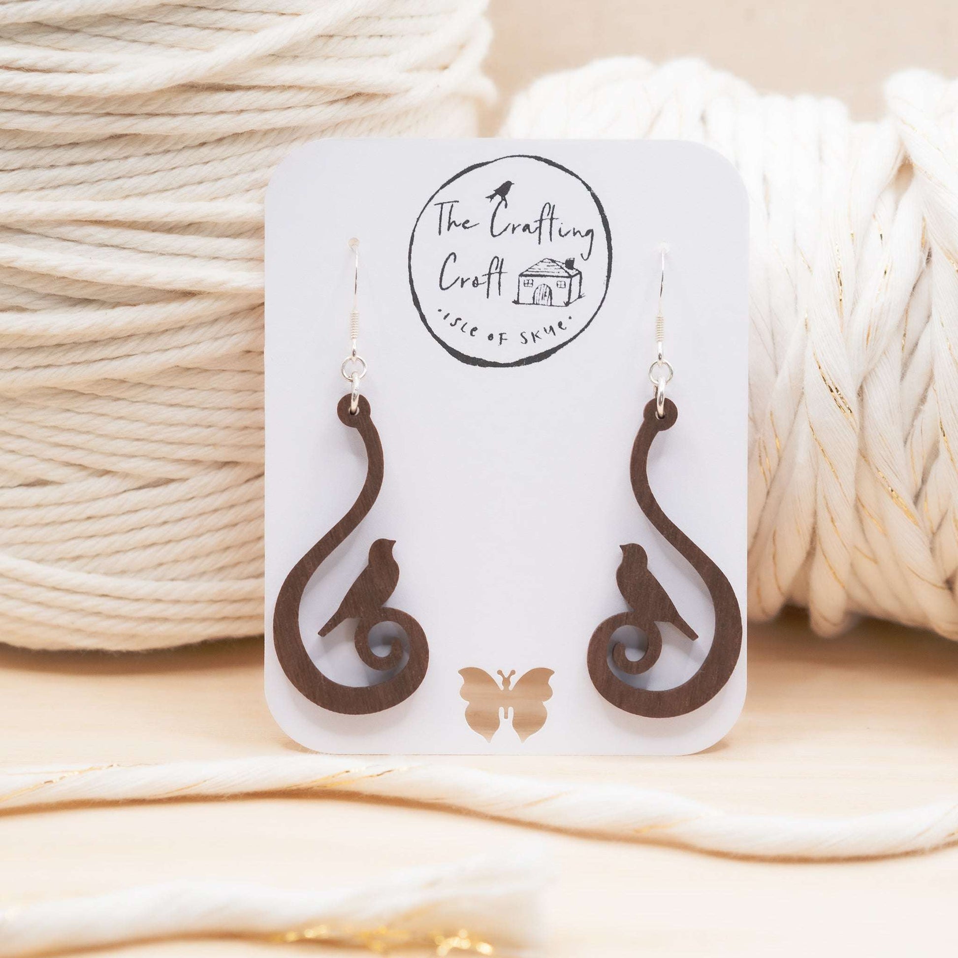 Swirling bird drop earrings in solid walnut laser cut and hand finished on The Isle of Skye Scotland